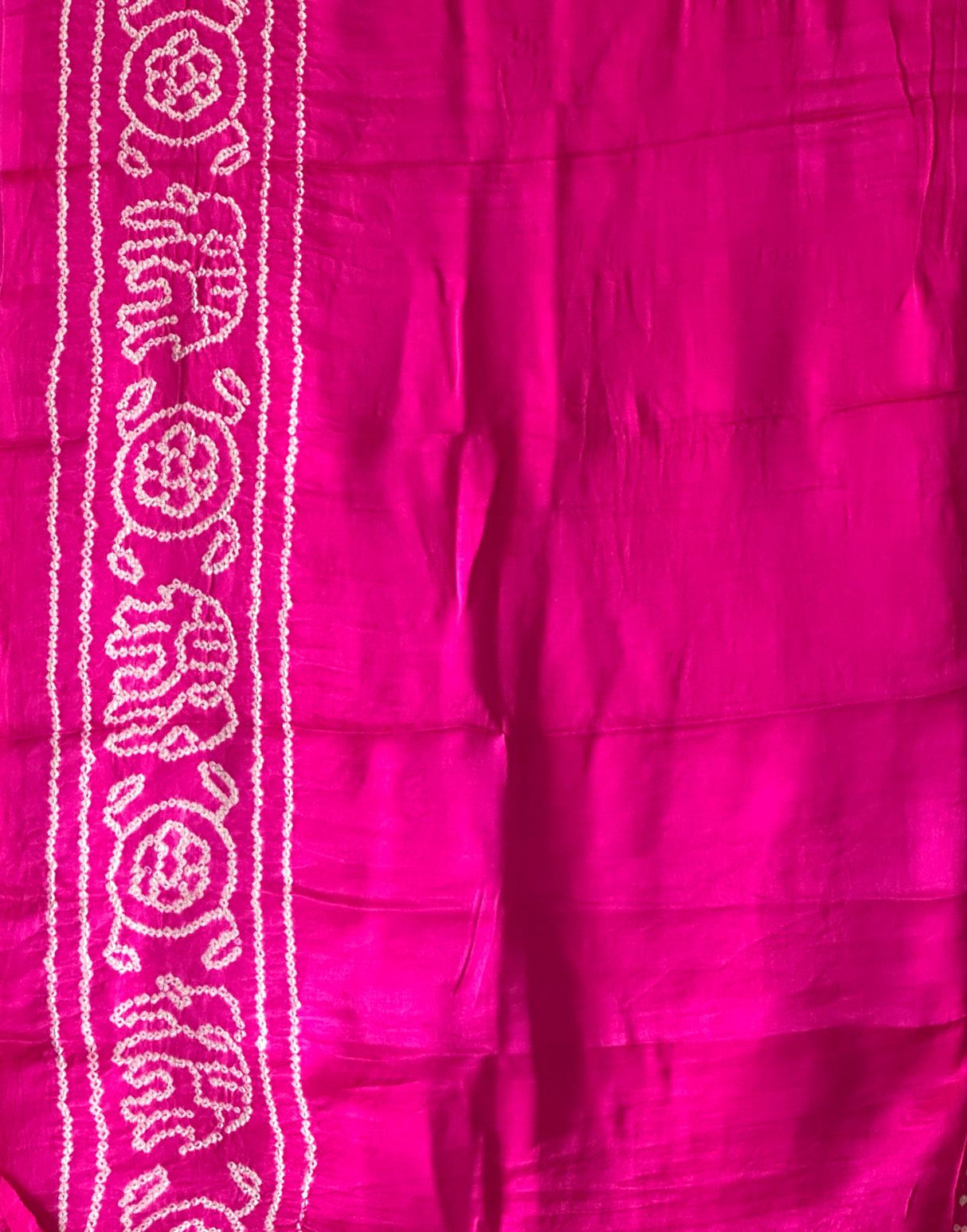 A pure Gajji silk pink and yellow bandhani saree draped and displayed, with intricate circle patterns.