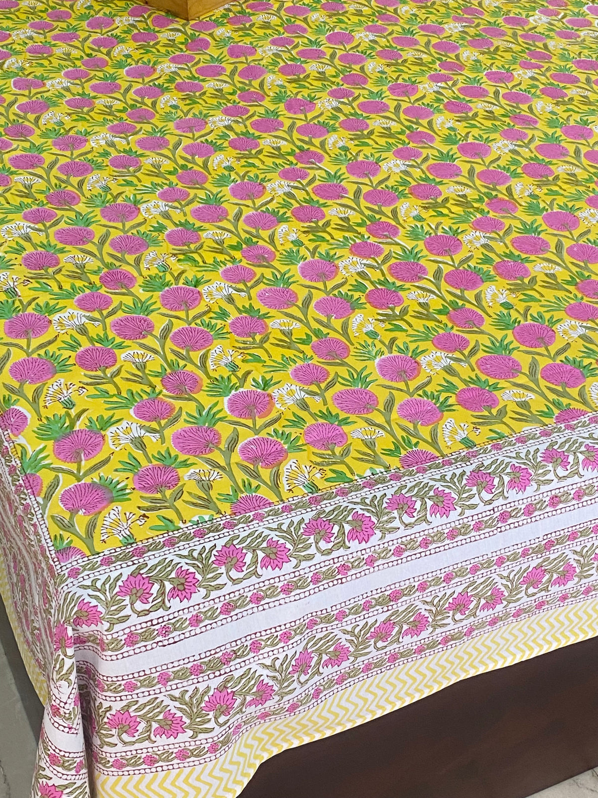 Yellow flat bedsheet with all over pink floral motifs