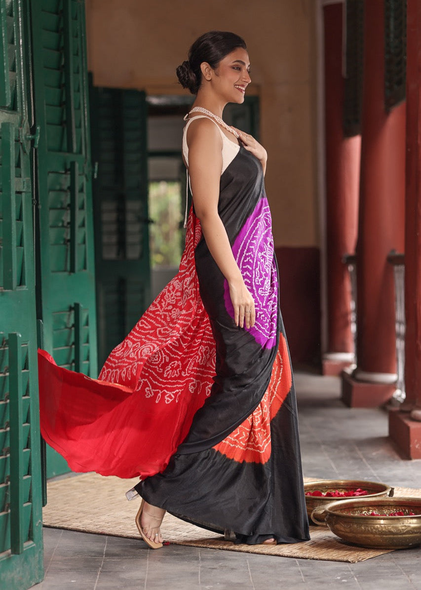 Woman in a colorful traditional outfit standing in a courtyard.