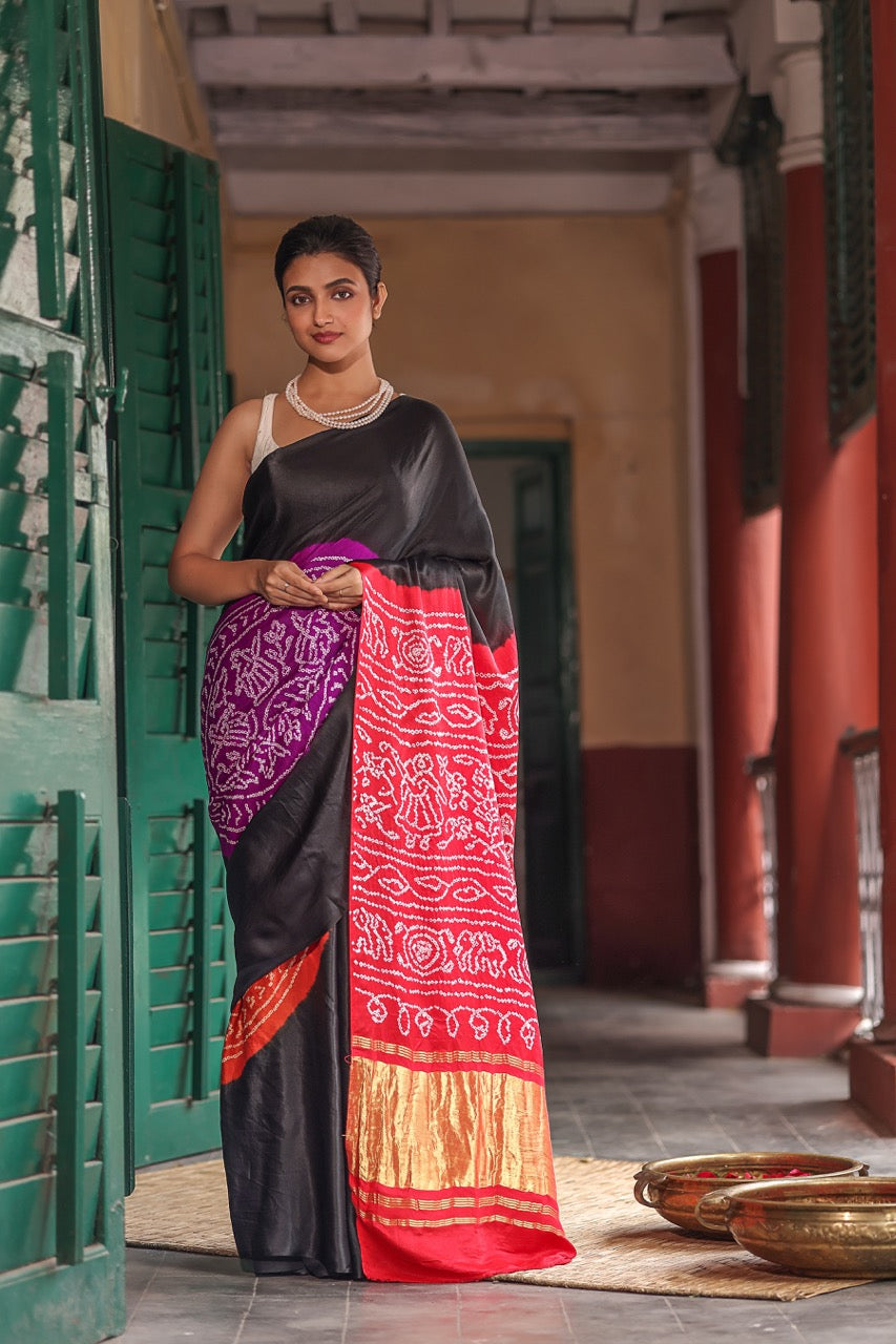 Woman in a colorful saree standing in a traditional setting