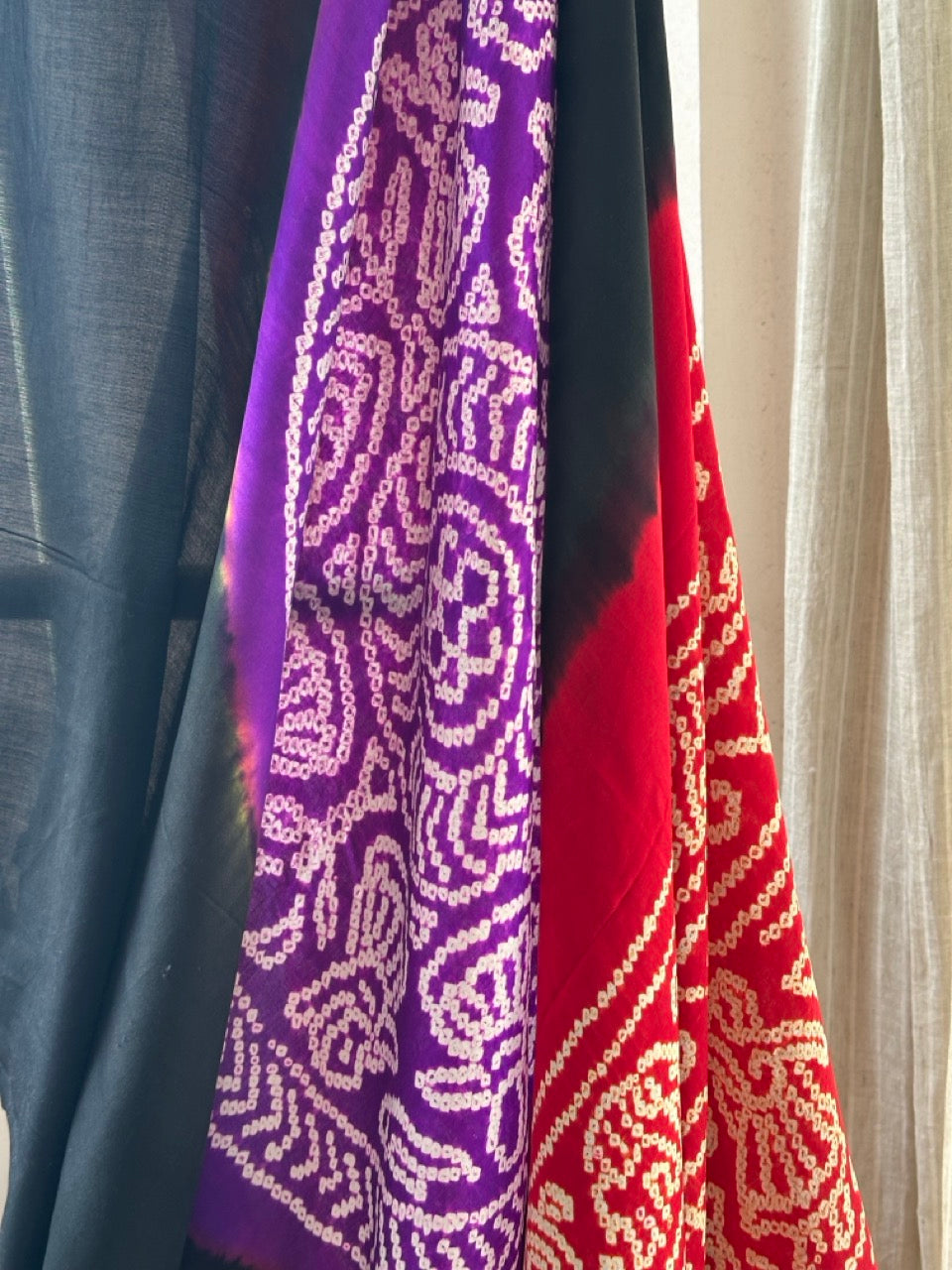 A pure Gajji silk bandhani saree with a black base and multicolored circle theme, displayed against a neutral background.
