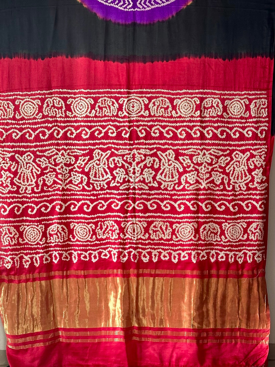 A pure Gajji silk bandhani saree with a black base and multicolored circle theme.