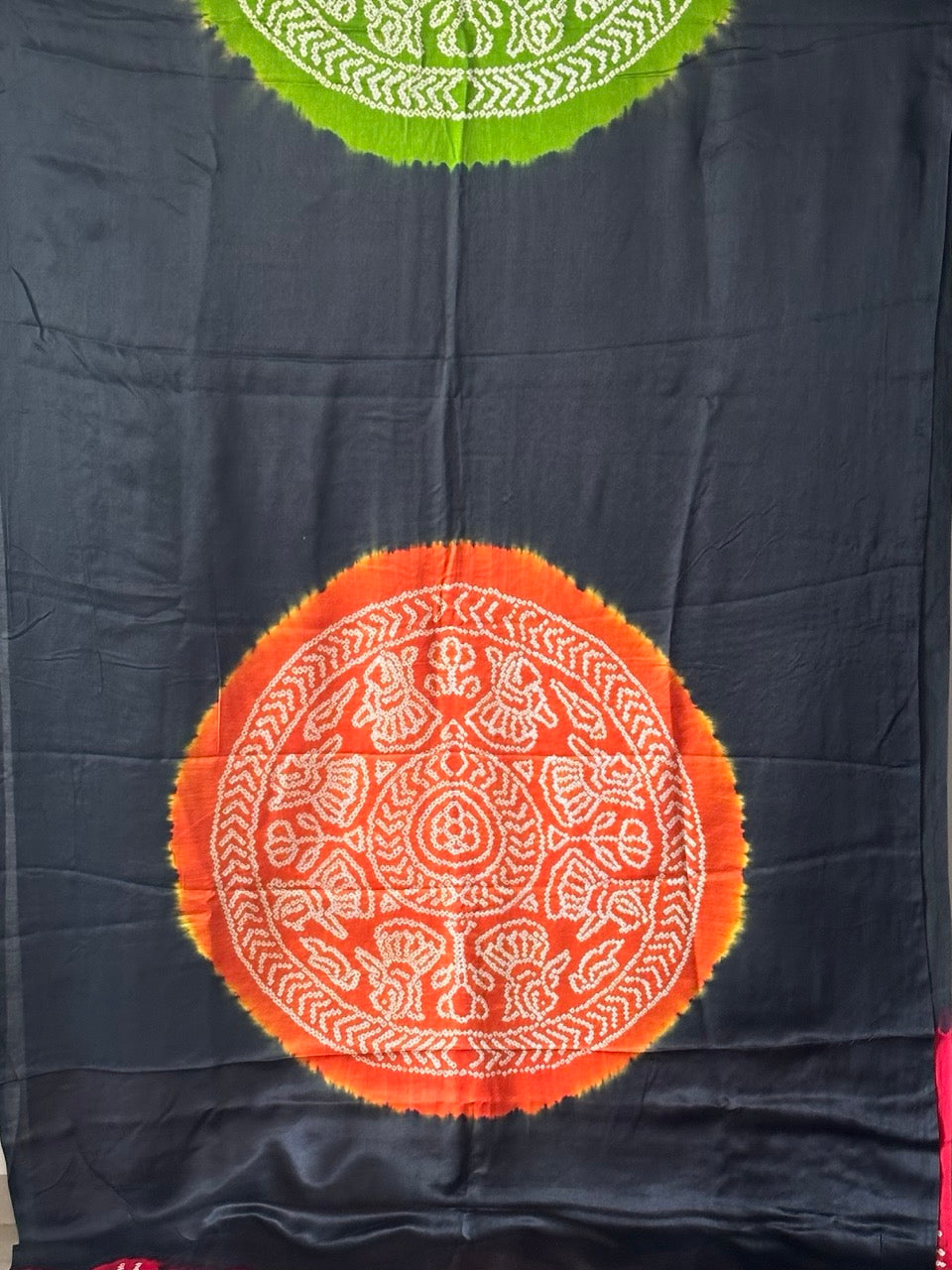 A pure Gajji silk bandhani saree with a black base and multicolored circle theme.