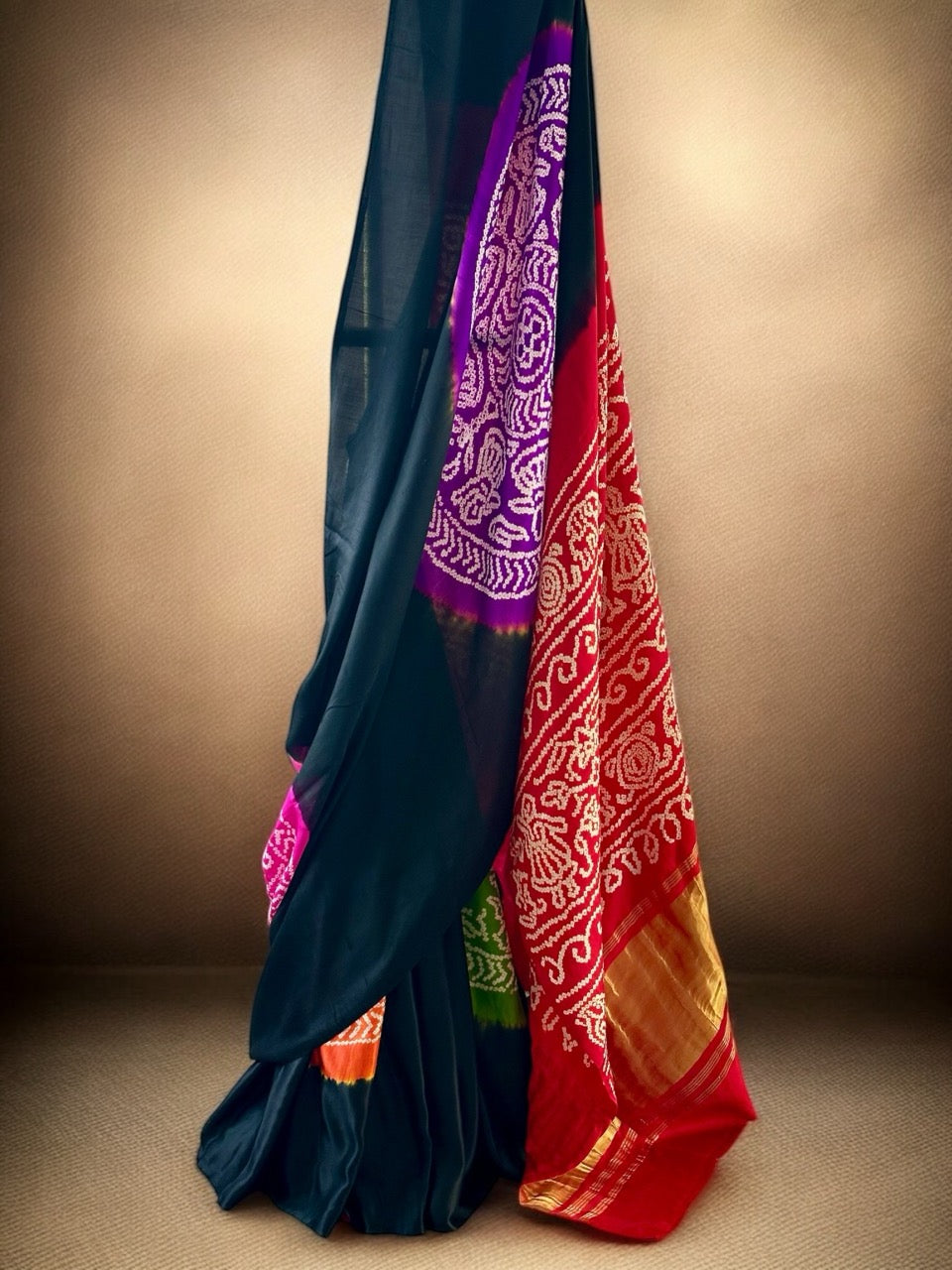 A pure Gajji silk bandhani saree with a black base and multicolored circle theme, displayed against a neutral background.