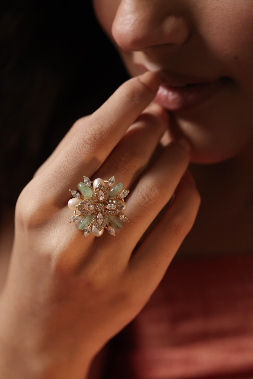 Close-up of a hand wearing a decorative ring with a dark background