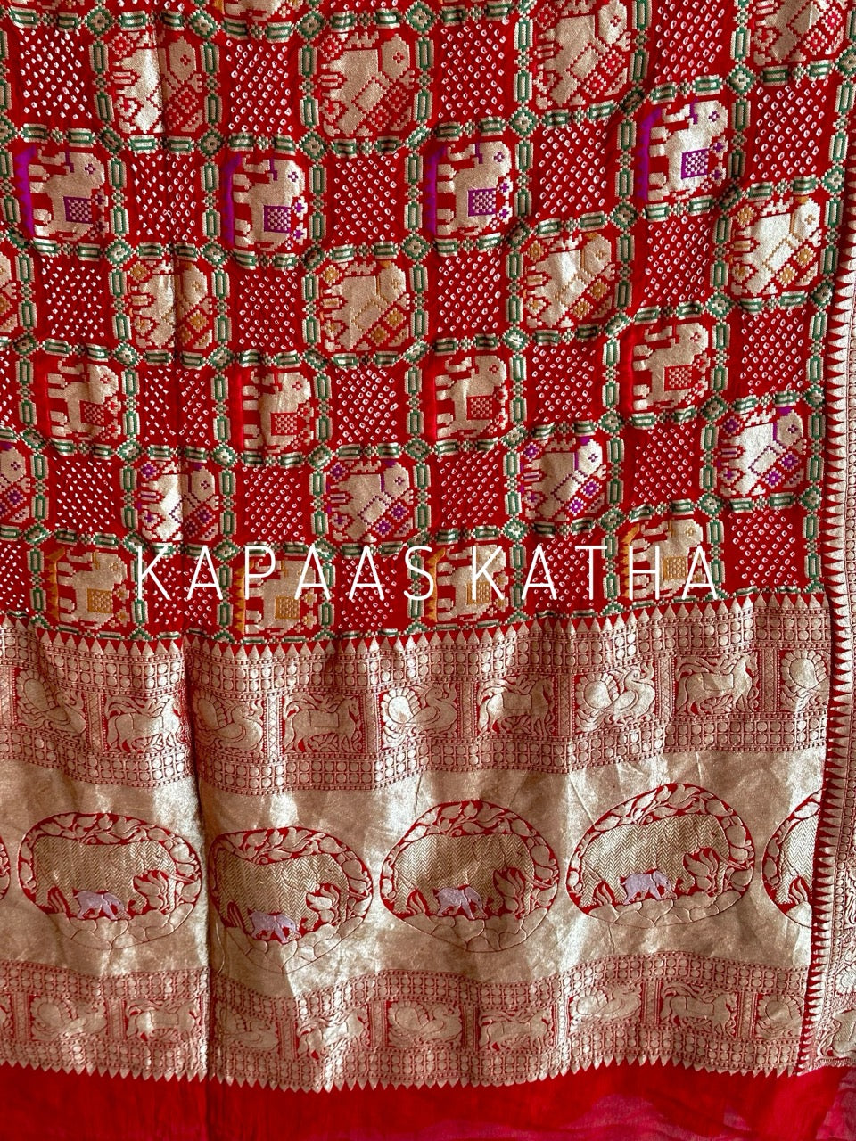 Buy pure Banarasi georgette Bandhani saree in vermilion red with gold zari elephant motifs & rich woven pallu. Authentic handloom luxury online at Kapaas Katha.