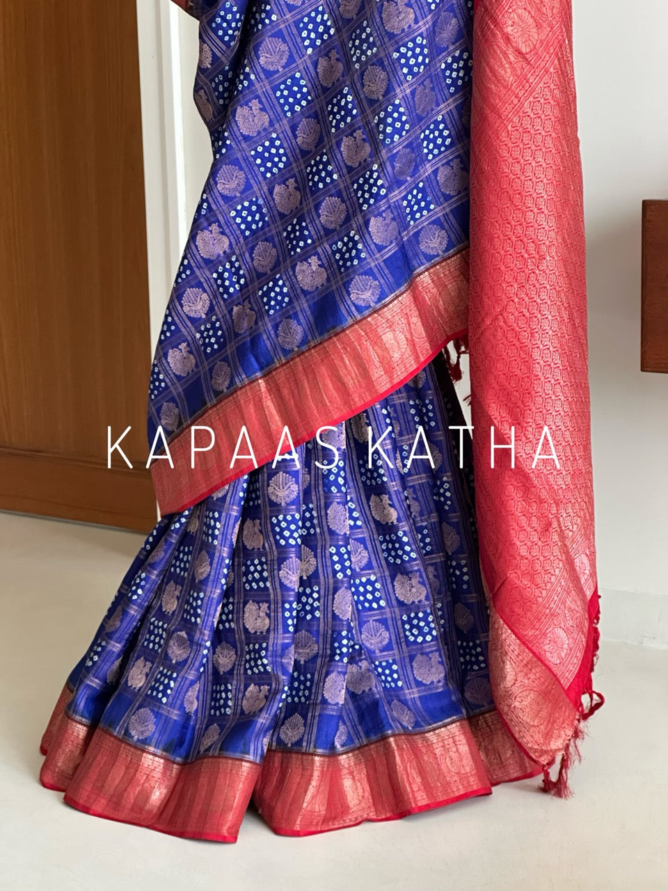 Buy pure Vasundhara silk Bandhani saree in royal blue with contrast crimson red zari border & rich pallu. Authentic handwoven luxury online at Kapaas Katha.