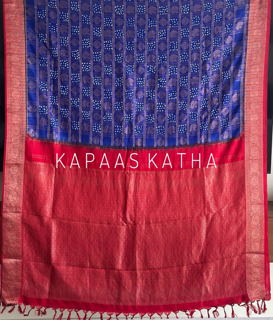 Buy pure Vasundhara silk Bandhani saree in royal blue with contrast crimson red zari border & rich pallu. Authentic handwoven luxury online at Kapaas Katha.