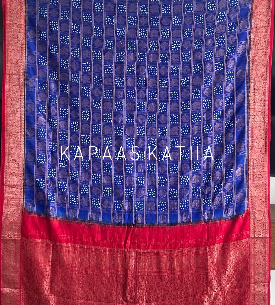 Buy pure Vasundhara silk Bandhani saree in royal blue with contrast crimson red zari border & rich pallu. Authentic handwoven luxury online at Kapaas Katha.