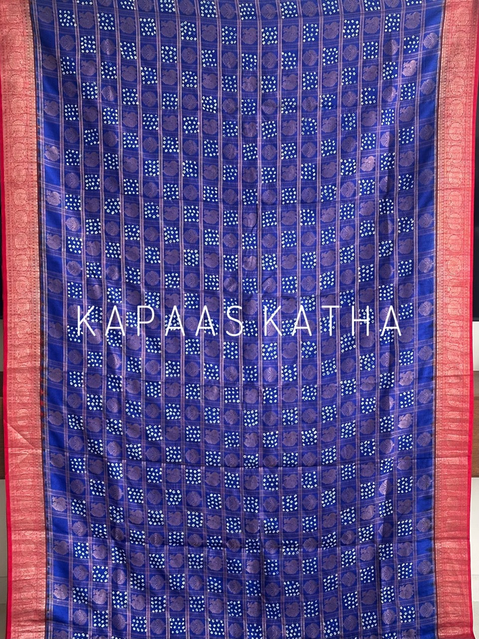 Buy pure Vasundhara silk Bandhani saree in royal blue with contrast crimson red zari border & rich pallu. Authentic handwoven luxury online at Kapaas Katha.