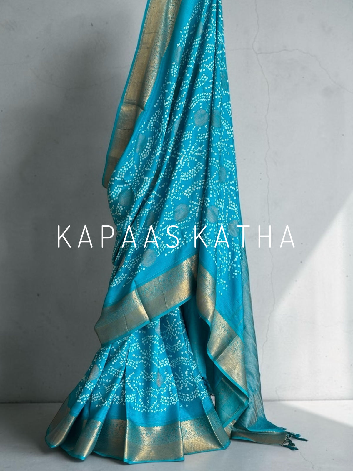 Buy pure Vasundhara silk Bandhani saree in turquoise blue with gold zari leaf motifs & rich pallu. Authentic handwoven luxury online at Kapaas Katha.