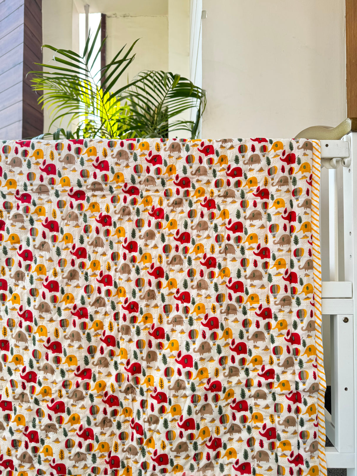 soft mulmul reversible jungle quilt with handprinted elephants on one side and giraffes with animal friends on back for gifting in Ireland and Dubai