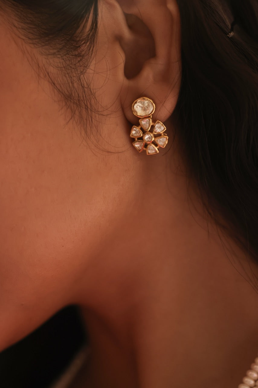 Woman in a pink saree with 92.5 silver jewelry with moissanite polki  and pearls holding flowers indoors