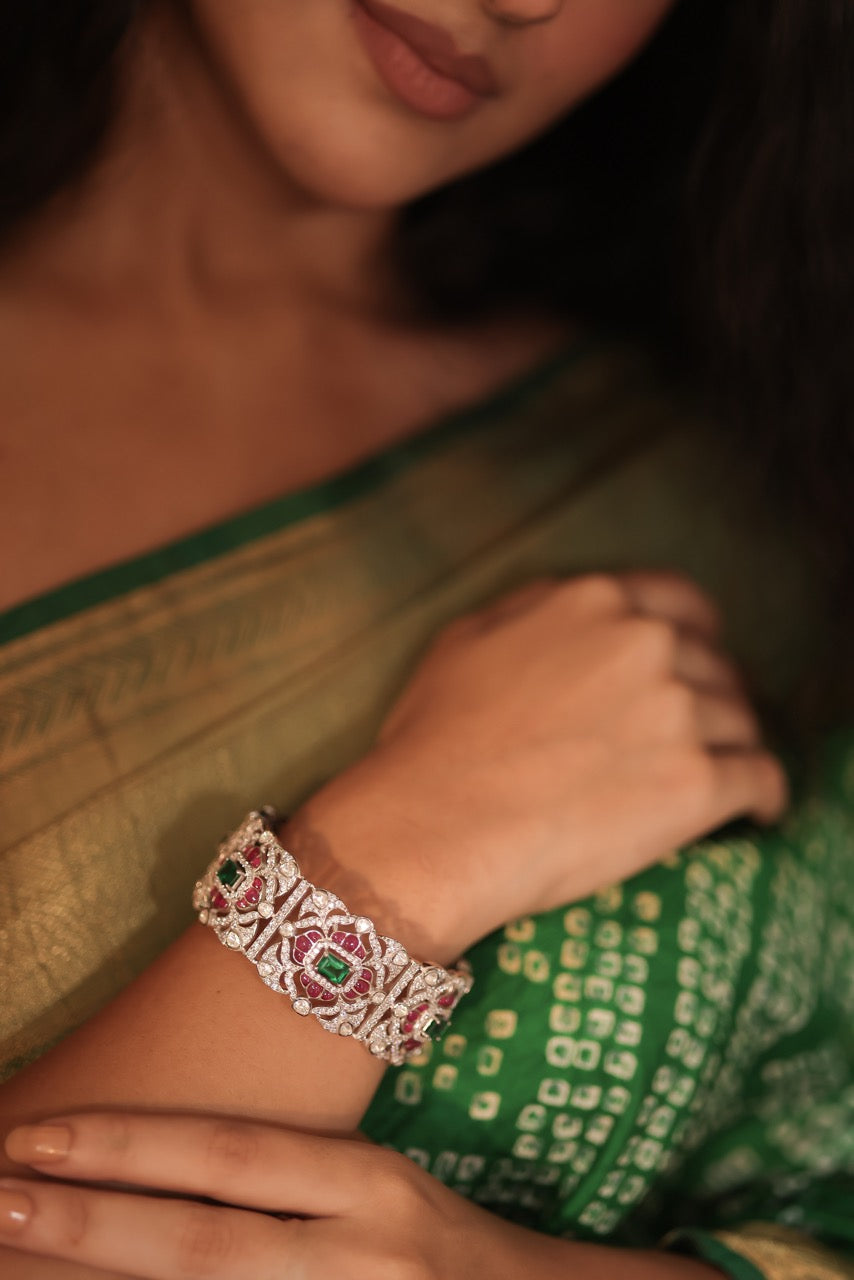 Close-up of a person wearing a bracelet with gemstones, set against a blurred background.