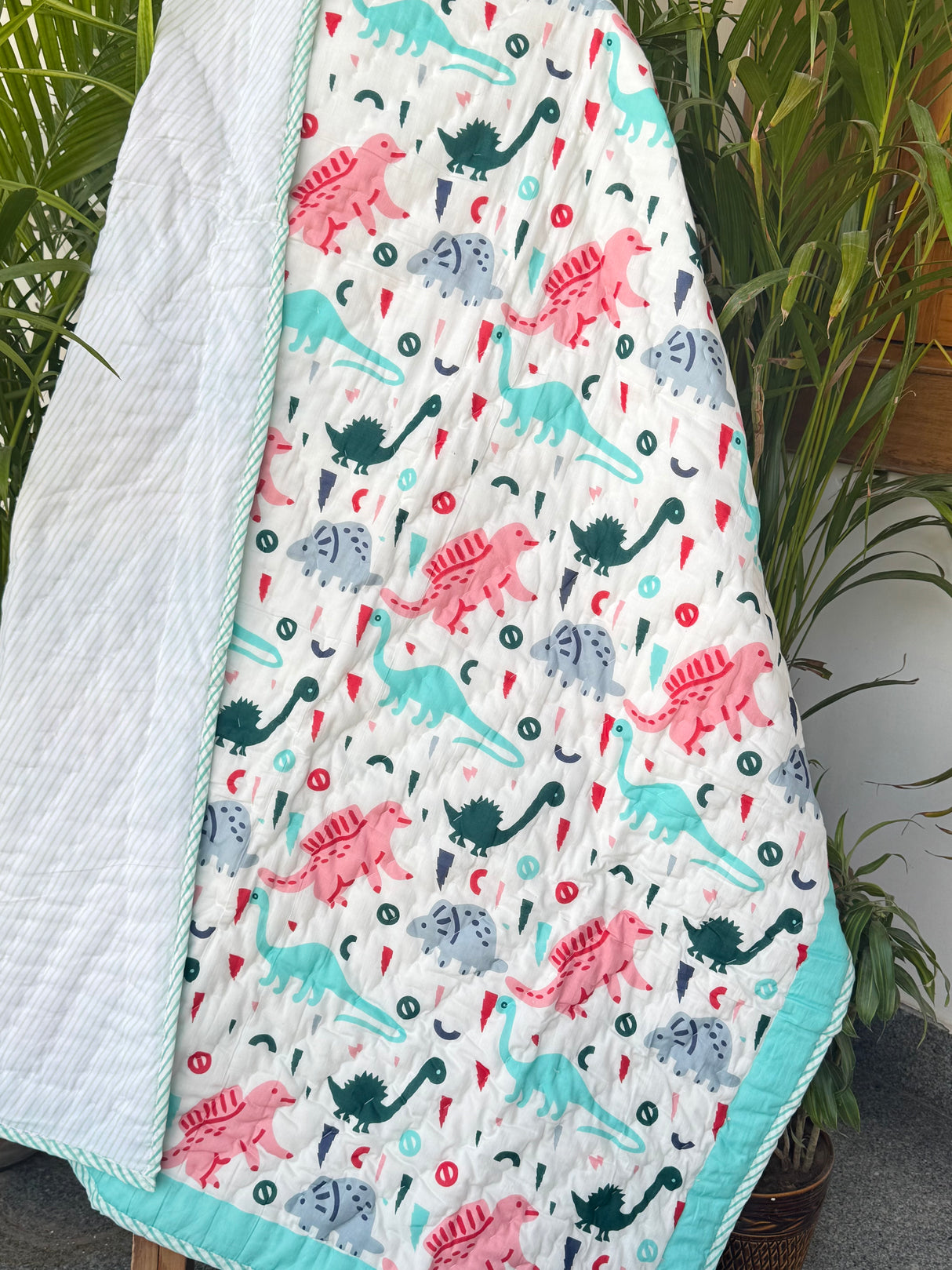 handcrafted dinosaur cotton quilt in turquoise and multicolor palette for toddler birthdays in South Africa and New Zealand