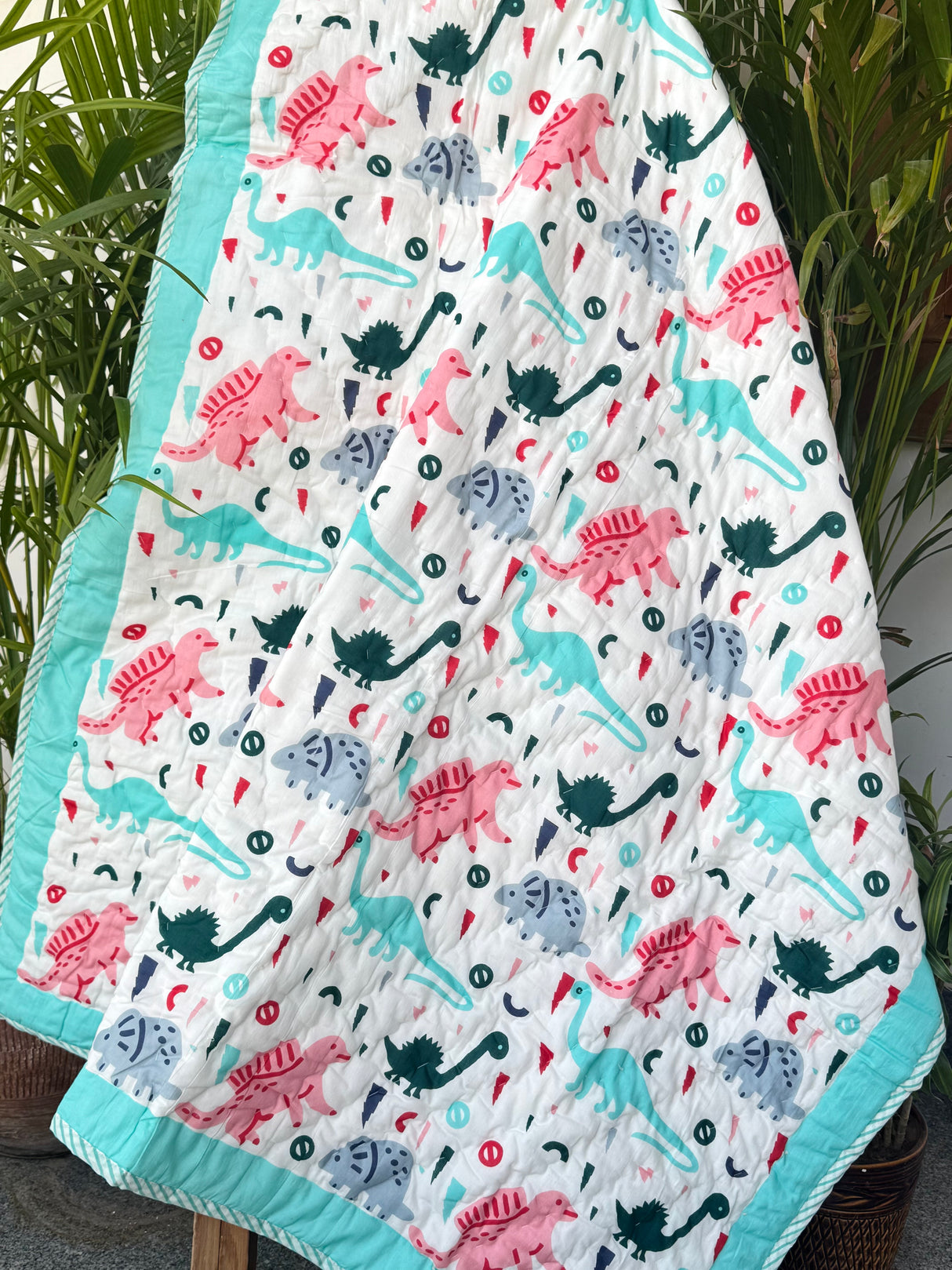 multicolored dinosaur theme quilt for toddlers in turquoise tones handmade in Jaipur for bulk gifting in Canada and UAE