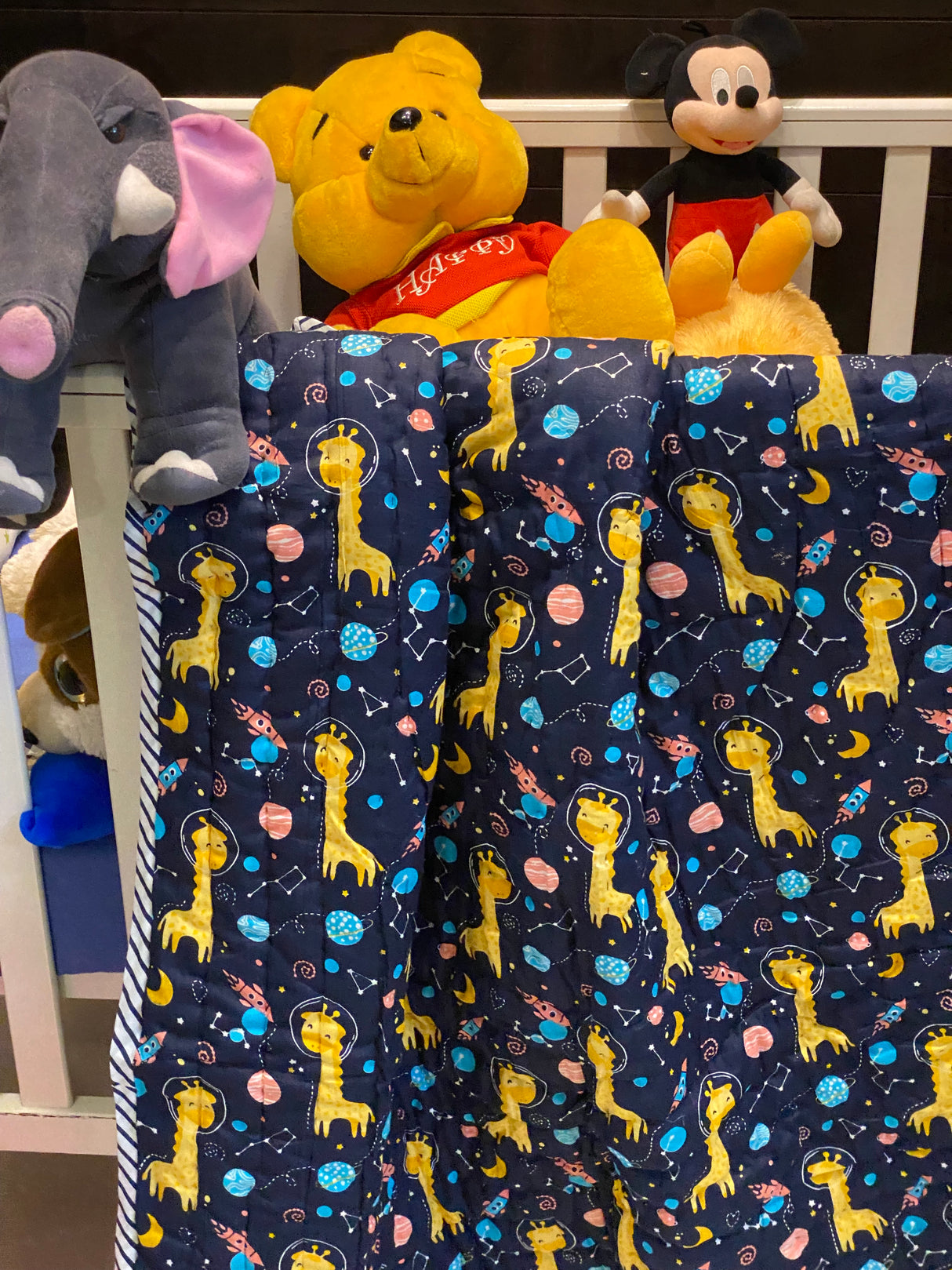 artisan made cotton quilt with playful blue giraffes and rockets suitable for toddler beds and gifting in USA and UK
