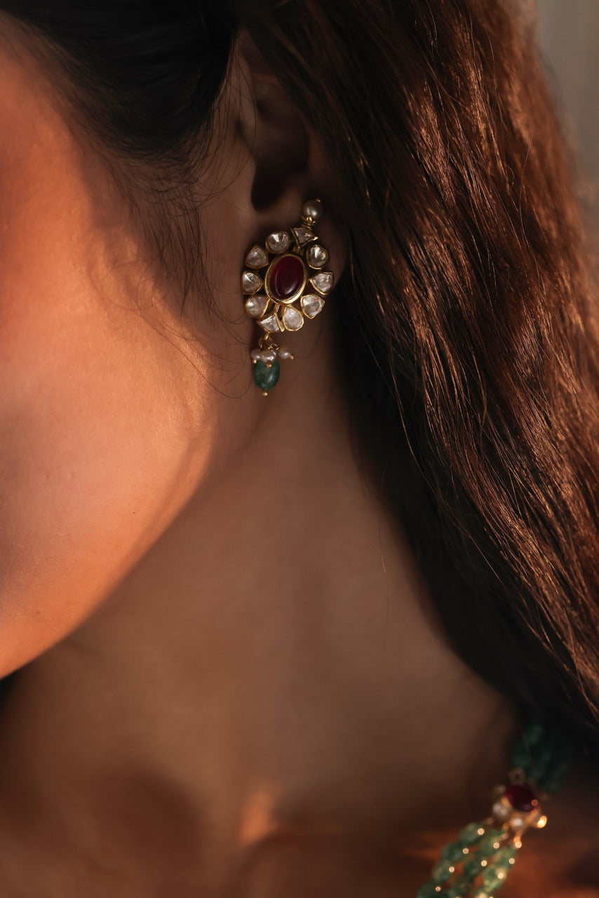 Close-up of a person wearing an ornate earring with a blurred background