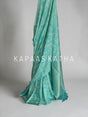 Shop pure Vasundhara silk Bandhani saree in sea green with gold zari checks & rich tissue pallu. Authentic handwoven luxury online at Kapaas Katha.