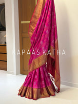A draped pink and gold Banarasi silk saree with intricate zari work.