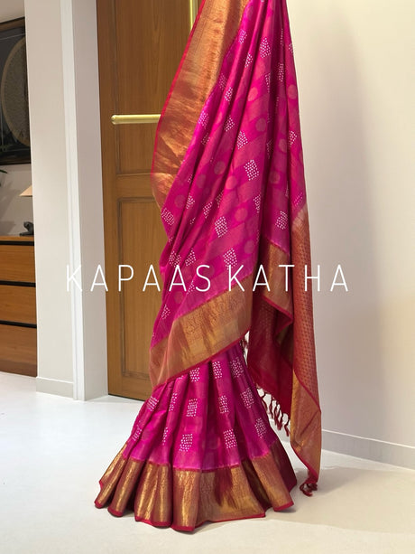 A draped pink and gold Banarasi silk saree with intricate zari work.