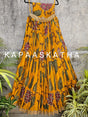 Yellow floral dress on a hanger with 'Kapaaskatha' branding against a gray textured wall.