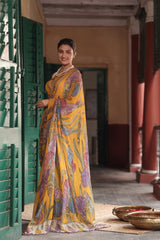 Woman in a yellow saree with floral patterns standing in a traditional setting.