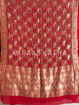 Buy pure Banarasi georgette Bandhani saree in vermilion red with gold zari elephant motifs & rich woven pallu. Authentic handloom luxury online at Kapaas Katha.