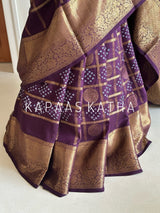 Buy pure Vasundhara silk Bandhani saree in plum purple with gold zari checks & rich pallu. Authentic handwoven luxury online at Kapaas Katha.