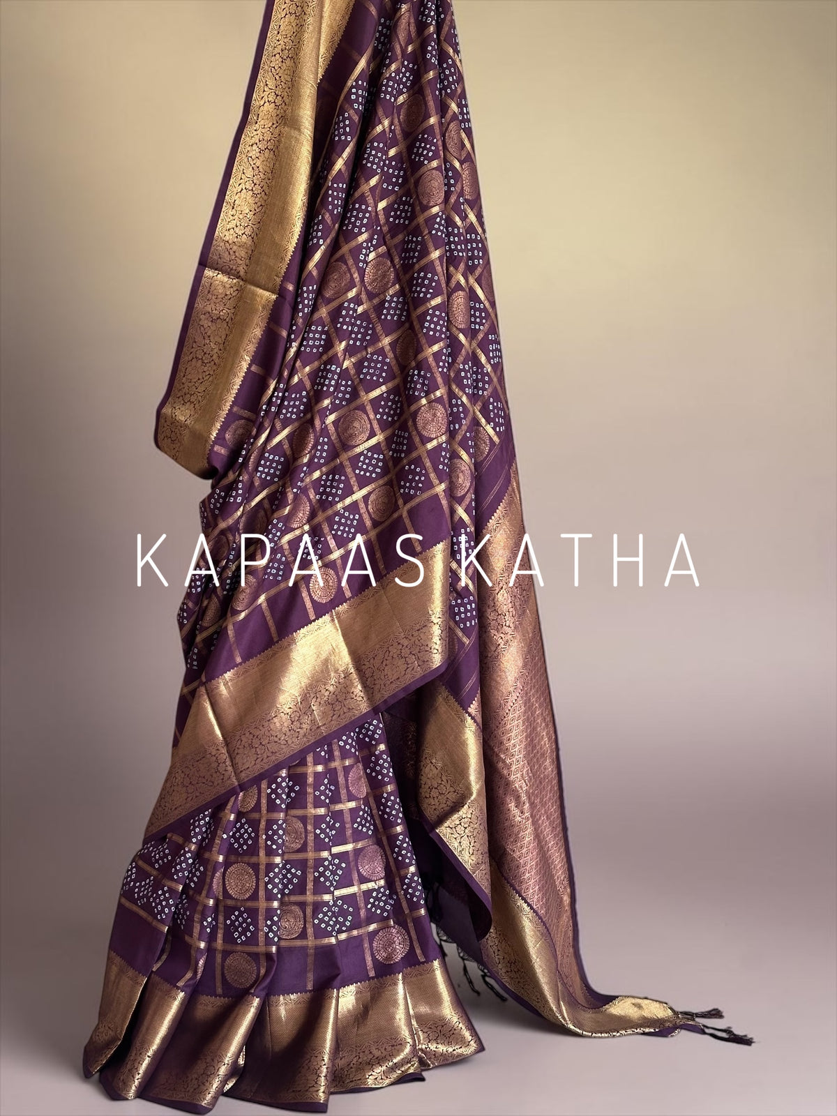 Buy pure Vasundhara silk Bandhani saree in plum purple with gold zari checks & rich pallu. Authentic handwoven luxury online at Kapaas Katha.