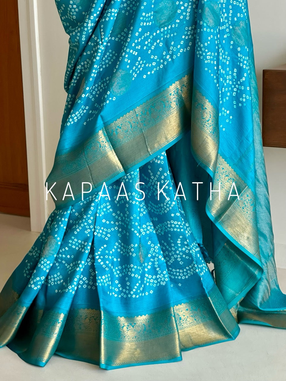 Buy pure Vasundhara silk Bandhani saree in turquoise blue with gold zari leaf motifs & rich pallu. Authentic handwoven luxury online at Kapaas Katha.