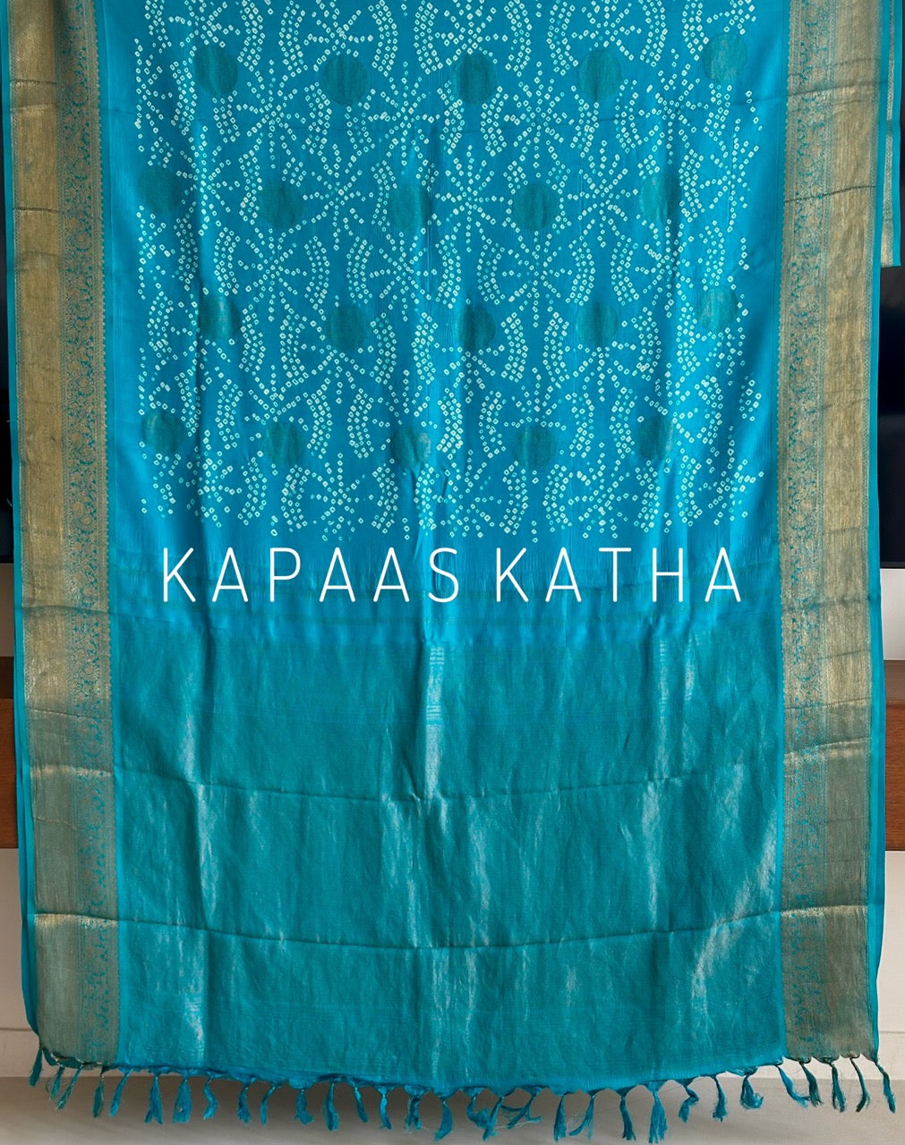 Buy pure Vasundhara silk Bandhani saree in turquoise blue with gold zari leaf motifs & rich pallu. Authentic handwoven luxury online at Kapaas Katha.