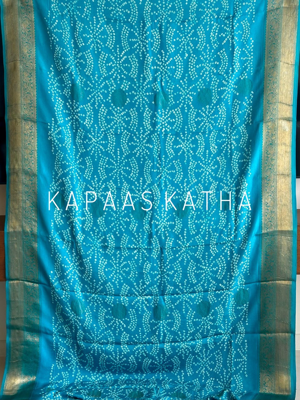 Buy pure Vasundhara silk Bandhani saree in turquoise blue with gold zari leaf motifs & rich pallu. Authentic handwoven luxury online at Kapaas Katha.