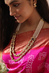 Woman in a pink saree with 92.5 silver jewelry with moissanite polki  and pearls holding flowers indoors