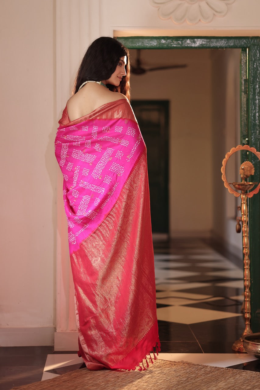 Woman wearing a pink saree with a white border in an indoor setting