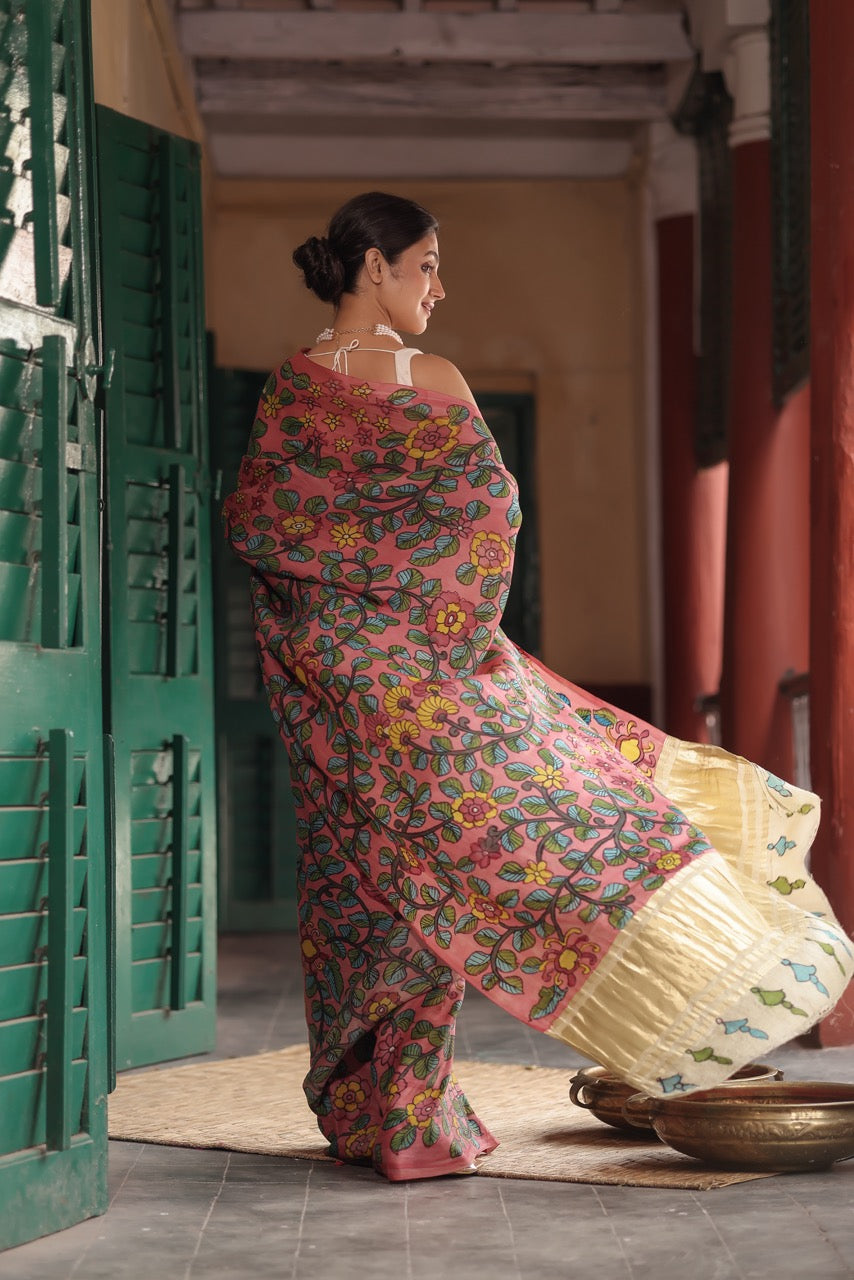 Woman in a colorful saree standing in a traditional setting