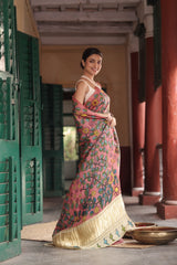 Woman in a traditional saree standing in an outdoor setting with architectural elements.
